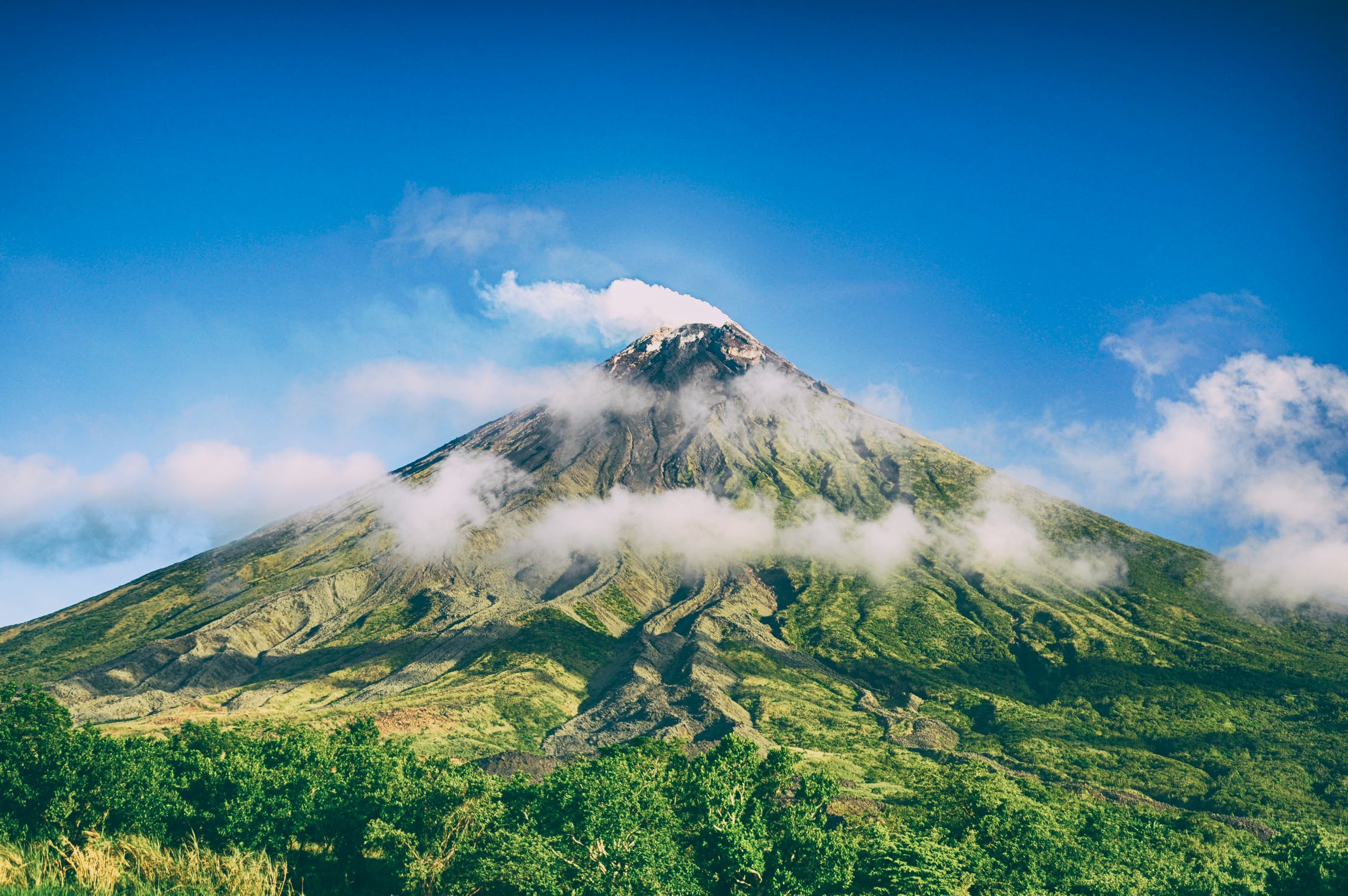 Green volcanic slopes wrapped in clouds